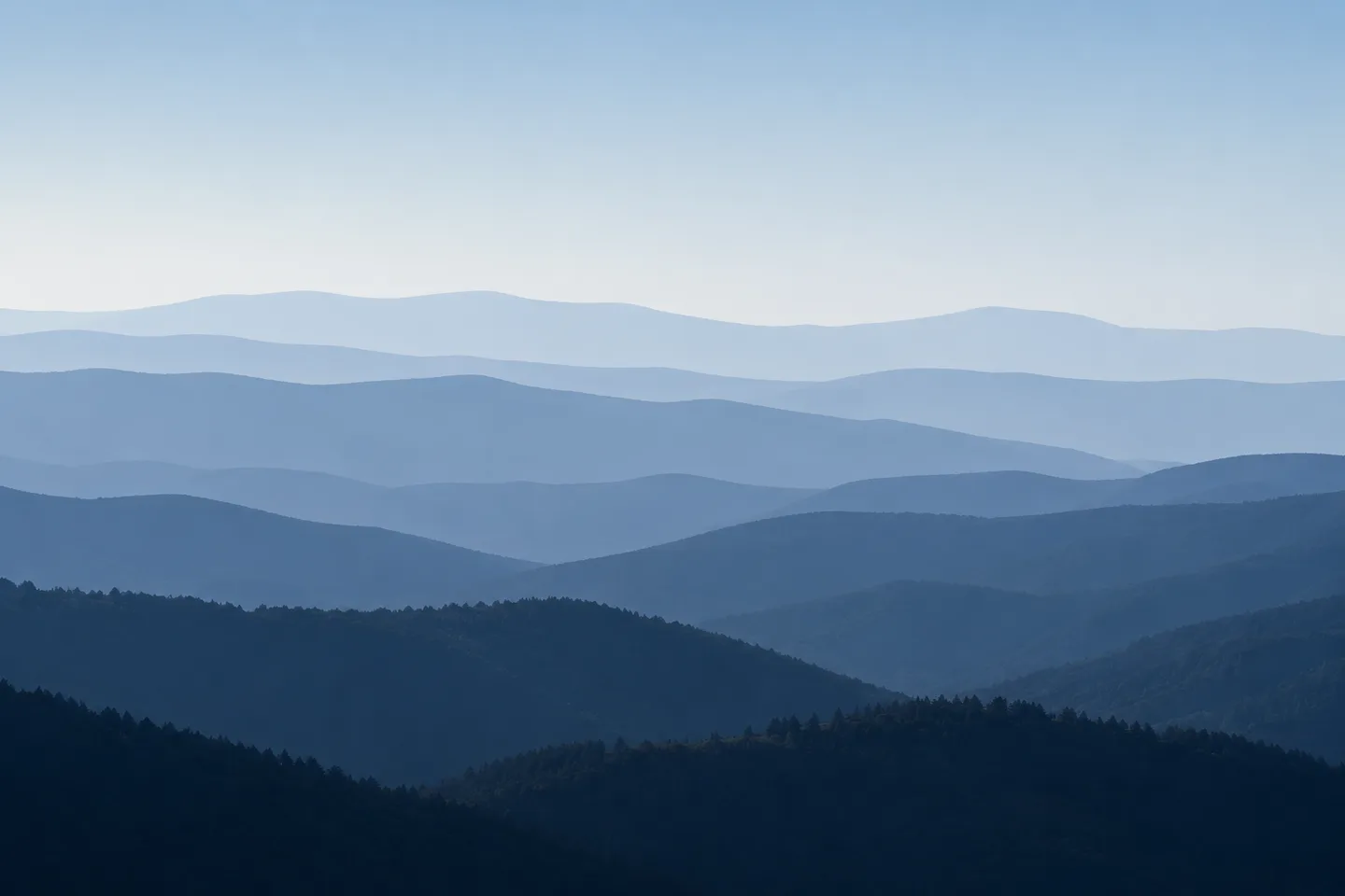 Layered blue mountain ridges receding into haze — successive horizons.